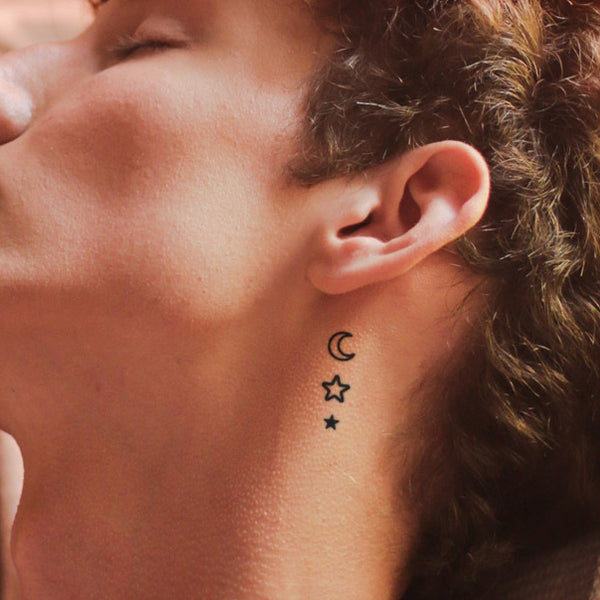 Minimalist North Stars tattoo behind the ear.